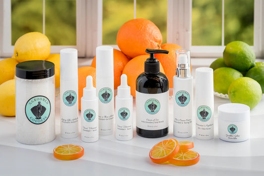 Collection of skincare products  by The Groomed Goddess with citrus fruits on a white surface