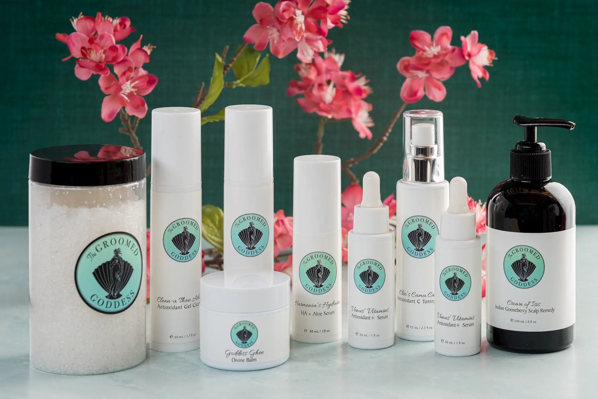 Collection of skincare products with a brand logo on a green background with pink flowers.